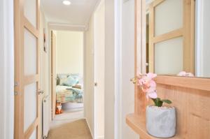 a hallway with a vase with flowers in it at Foxes Heart in Ryde