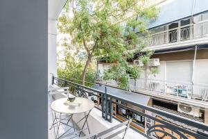balkon ze stołem i krzesłami w budynku w obiekcie Luxury Bauhaus Athens w Atenach