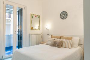a white bedroom with a large white bed with pillows at Maiori Apartment by Marcel in Maiori