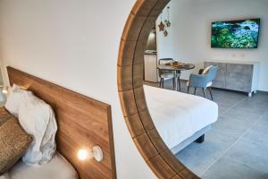 Schlafzimmer mit einem Bett und einem Spiegel in der Unterkunft Pure Thermal Residence in Roquebillière