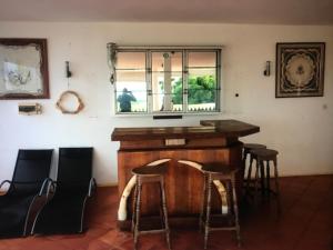 un bar en una habitación con taburetes y ventana en La Villa Ingrid en Antsiakambony