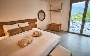 sypialnia z dużym łóżkiem i dużym oknem w obiekcie Pure Thermal Residence w mieście Roquebillière