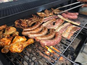 a bunch of sausage and other meats on a grill at Camping De La Vallée in Durbuy