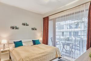 a bedroom with a bed and a large window at Apartamenty Świnoujście - Baltic Park in Świnoujście