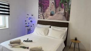um quarto com uma cama branca e uma fotografia na parede em Villa Zigana em Mostar