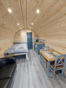 una habitación con una cama y una mesa en una cabaña en Loch Caroy Pods en Ose
