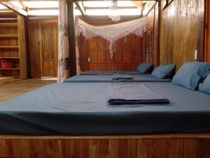 a large bed in a room with blue sheets at Du Gia Wooden Homestay in Làng Cac