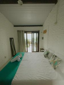 a large white bed in a room with a window at CASA VIDASURF in Pipa