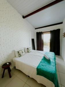 a bedroom with a bed with a blue blanket on it at CASA VIDASURF in Pipa
