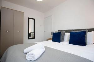 a bedroom with a large white bed with blue pillows at HC Property - Cromwell Avenue in Newcastle upon Tyne