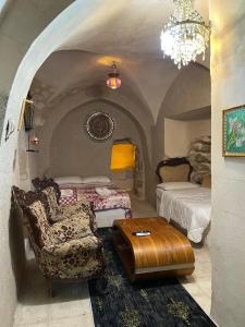 Zimmer mit 2 Betten, einem Stuhl und einem Tisch in der Unterkunft Acabey Konuk Evleri in Mardin