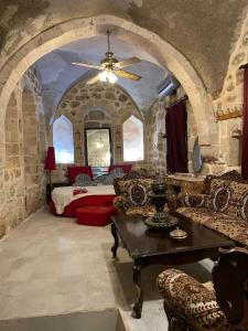 Zimmer mit einem Bett, einem Sofa und einem Tisch in der Unterkunft Acabey Konuk Evleri in Mardin