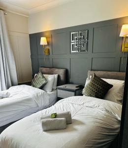Habitación de hotel con 2 camas y 2 sillas en Queensmead Hotel en Shanklin