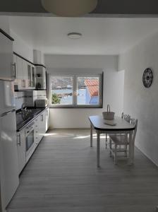 a kitchen with a table and a dining room at Apartamento Area Pequena Ézaro in Ézaro