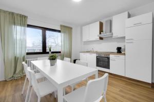 a white kitchen with a white table and chairs at Business-Apartment in Lippstadt in Lippstadt