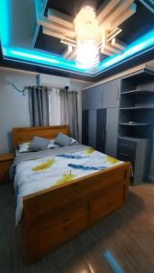 ein Schlafzimmer mit einem großen Holzbett in einem Zimmer in der Unterkunft Travellers&Backpackers Apartment in Calapan