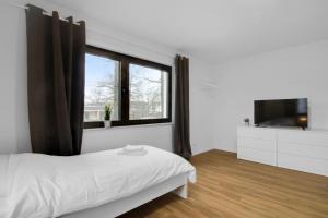 a white bedroom with a bed and a television at Business-Apartment in Lippstadt in Lippstadt