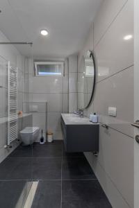 a white bathroom with a sink and a toilet at Villa Visum Mare Tribus in Mošćenička Draga