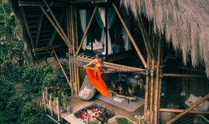 una donna su un'amaca in un resort di ATTRAVERSIAMO BAMBOO HOUSE a Manizales