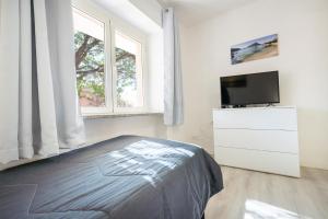 a bedroom with a bed and a flat screen tv at Appartamento Levante a 300m dalla spiaggia in Golfo Aranci