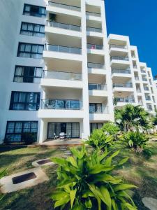 un edificio de apartamentos blanco con plantas delante en Modern Beachfront 3 Bedroom Mombasa near Nyali en Mombasa