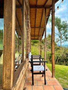 un porche de una casa con mesas y sillas en Refugio Aventura, espectacular cabaña en las montañas de Tabio, Cundinamarca, en Tabio