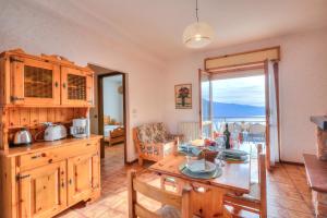 a kitchen with a table and a dining room at Residence Bellevue Country Style - Happy Rentals in Tremosine Sul Garda