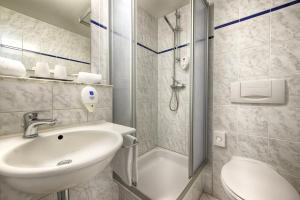 ein Bad mit einem Waschbecken, einer Dusche und einem WC in der Unterkunft enjoy hotel Berlin City Messe in Berlin