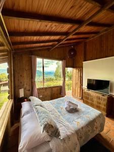 1 dormitorio con cama y ventana grande en Refugio Aventura, espectacular cabaña en las montañas de Tabio, Cundinamarca, en Tabio