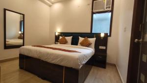 a bedroom with a large bed and a mirror at Hotel Admire Stay in Noida