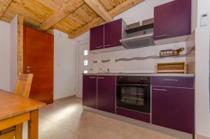 a kitchen with purple cabinets and a stove at Kuća Neven in Stomorska
