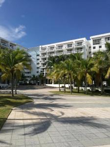 un grand bâtiment avec des palmiers devant lui dans l'établissement Playa Blanca Town Center B, à Río Hato