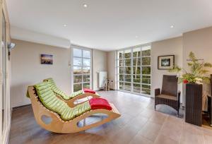 ein Wohnzimmer mit einem Sofa und einem Stuhl in der Unterkunft Residenz am Balmer See - BS 48 mit Wellnessbereich in Balm