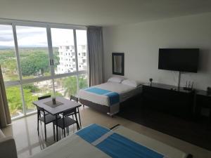 une chambre d'hôtel avec un lit, une table et une télévision dans l'établissement Playa Blanca Town Center B, à Río Hato