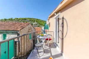 a balcony with a table and chairs on it at Kuća Neven in Stomorska