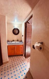 La salle de bains est pourvue d'un lavabo et d'un distributeur de papier toilette. dans l'établissement Riaad Hamad, à Fès