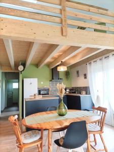 a kitchen and dining room with a wooden table and chairs at Havre de Paix 40 in Pouillon