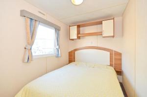 um pequeno quarto com uma cama e uma janela em Kingsgate, Shanklin, Isle of Wight em Shanklin