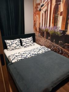 Una cama con dos almohadas encima. en Parkcity Kraków, en Cracovia