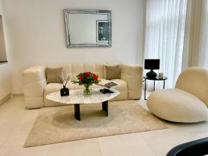 a living room with a couch and a table with flowers at Residence phoenix AP2 in Mons