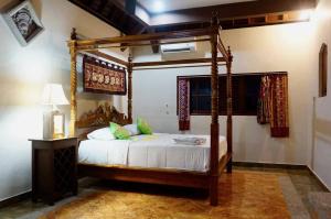 ein Schlafzimmer mit einem Himmelbett in einem Zimmer in der Unterkunft Near Ubud, Batuan Homestay Own King Bed Big Room at Royen Balinese Family Guest House in Sukawati
