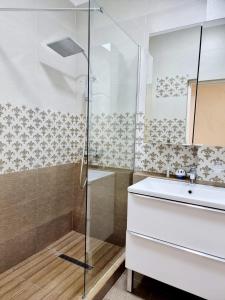 y baño con lavabo y ducha. en Apartament Aqua - Endless Summer Mamaia Nord Apartaments, en Mamaia Nord – Năvodari