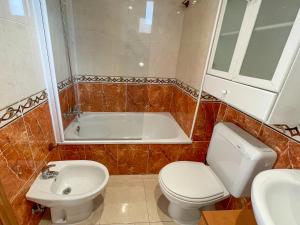 y baño con bañera, aseo y lavamanos. en Apartamentos Acapulco Marina D'Or 1º línea 3000 en Oropesa del Mar