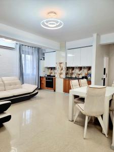 cocina y sala de estar con mesa y sillas en Apartament Aqua - Endless Summer Mamaia Nord Apartaments, en Mamaia Nord – Năvodari
