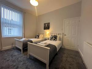 um quarto com 2 camas e uma janela em Hambledon- 2Bed downstairs flat Blyth em Blythe