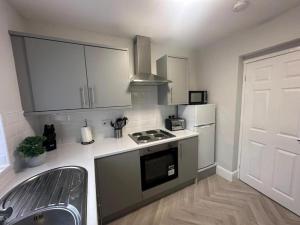 uma pequena cozinha com um fogão e um lavatório em Hambledon- 2Bed downstairs flat Blyth em Blythe