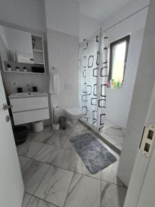 uma casa de banho branca com um WC e um lavatório em DA Residence em Otopeni