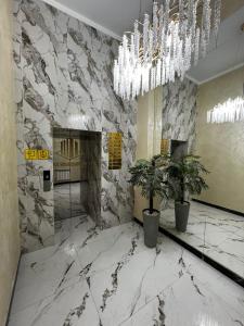 una hall con una parete in marmo e un lampadario a braccio di ЖК Жаксылык a Kökşetaw