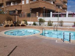 una gran piscina frente a un edificio en Apartamentos Acapulco Marina D'Or 1º línea 3000 en Oropesa del Mar