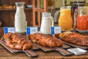 a table with different types of pastries and bottles of milk at Pousada Mãe D'Água in Tiradentes